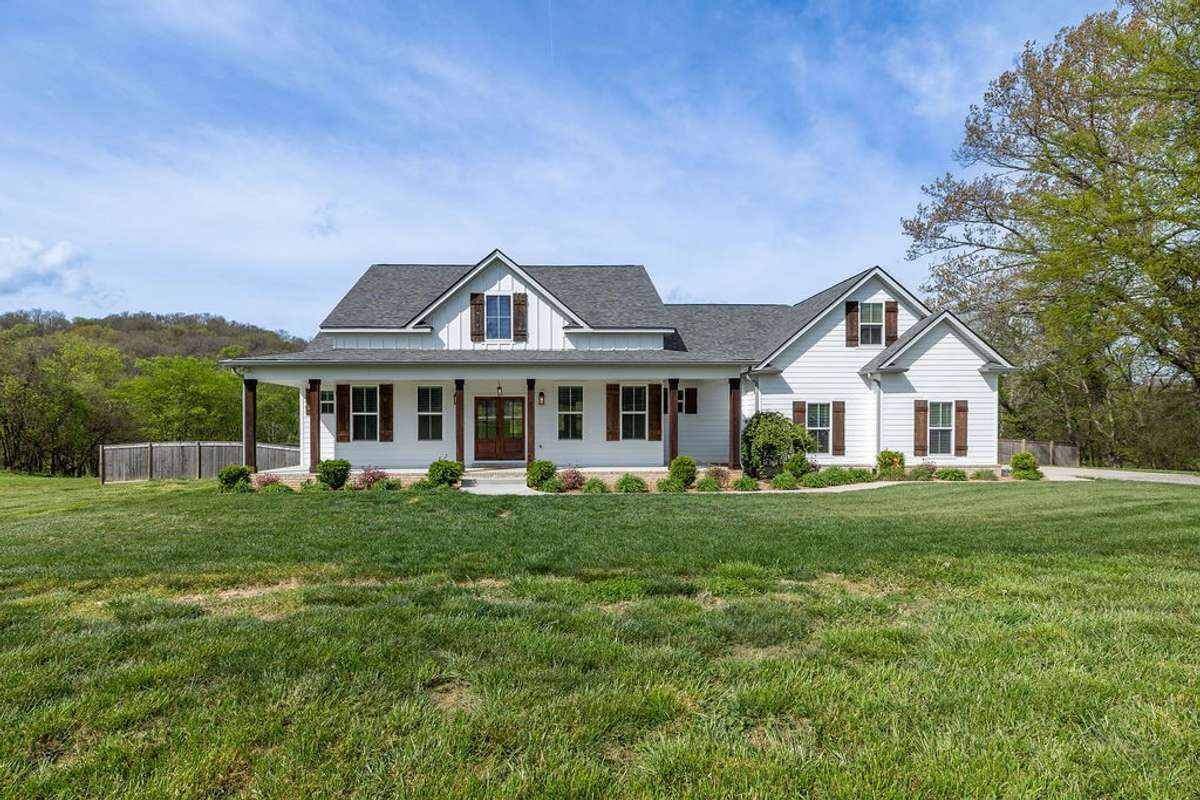 View of home from the front showing trees and large yard (12 Acres)