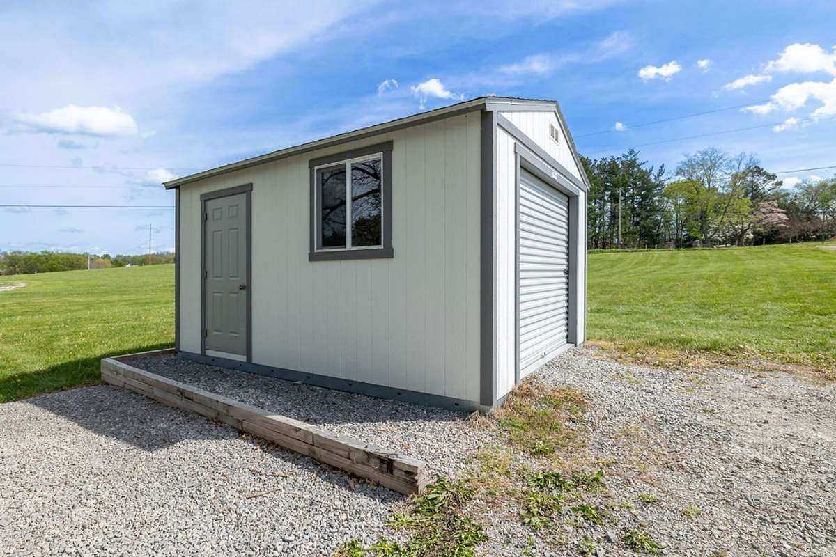 Storage Shed for gardening tools, lawn mowers, etc.  Has a garage door for larger items to be put inside