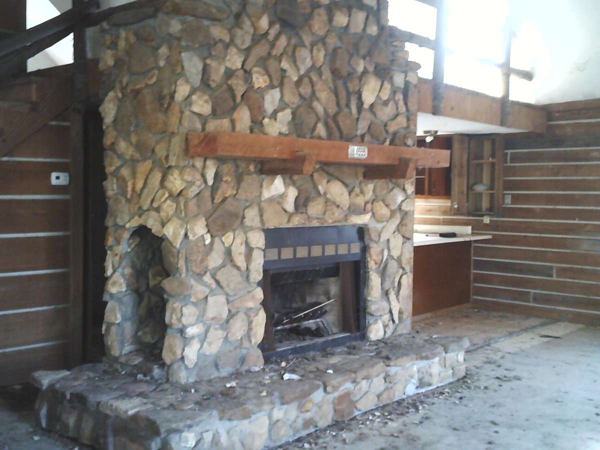 Gorgeous Fireplace with wood storage in open living and dining area which has a  two stories high ceiling