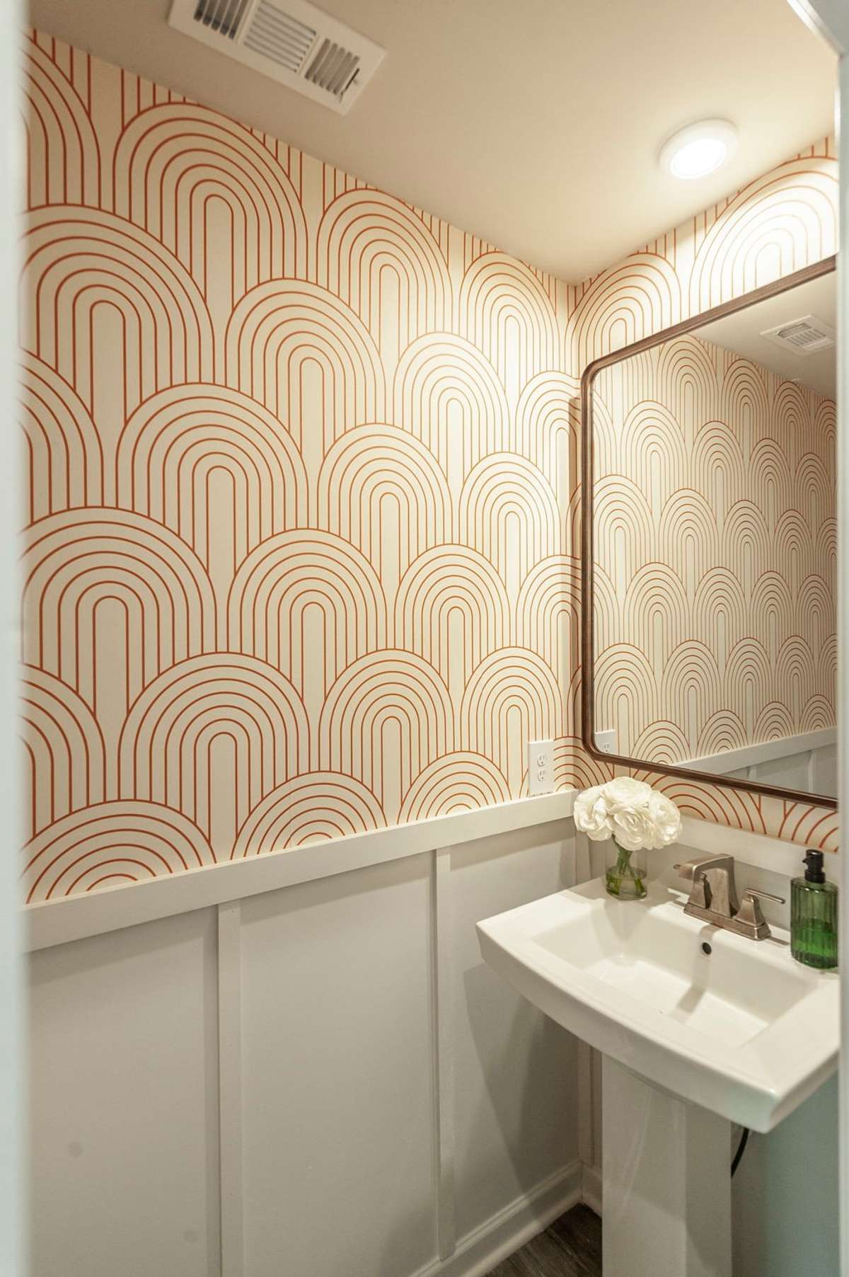 Wainscoting trim enhances the elegance of this thoughtfully designed half bath, creating a polished look.