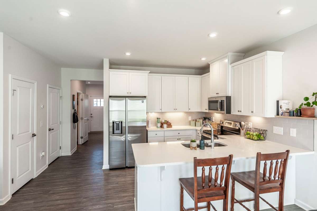 Bright white cabinetry paired with granite countertops creates a clean, modern kitchen that’s both stylish and functional.