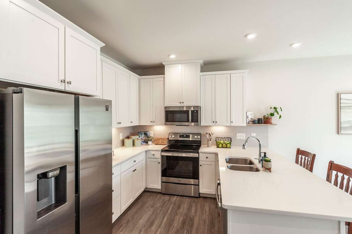Stainless steel appliances, including refrigerator, oven, and microwave, bring a sleek, contemporary touch to the kitchen.