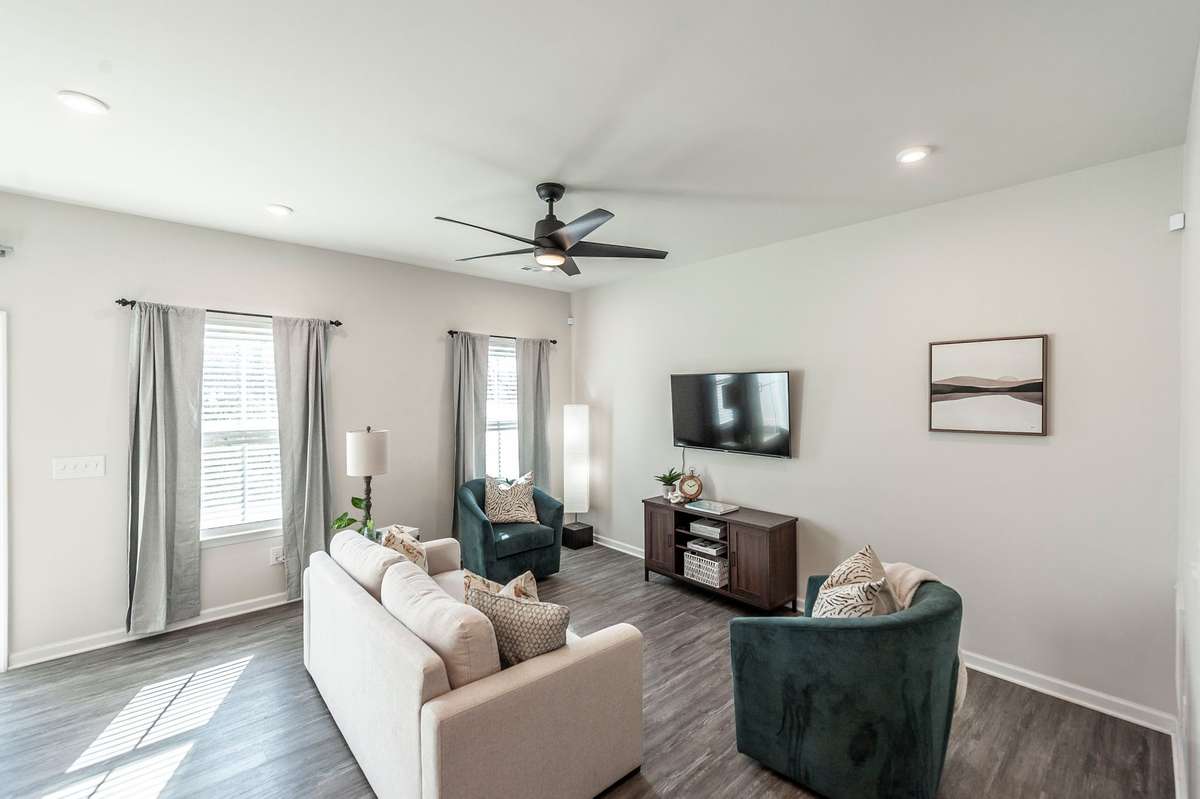 Spacious living room filled with natural light, creating a warm and inviting atmosphere perfect for relaxing or entertaining.