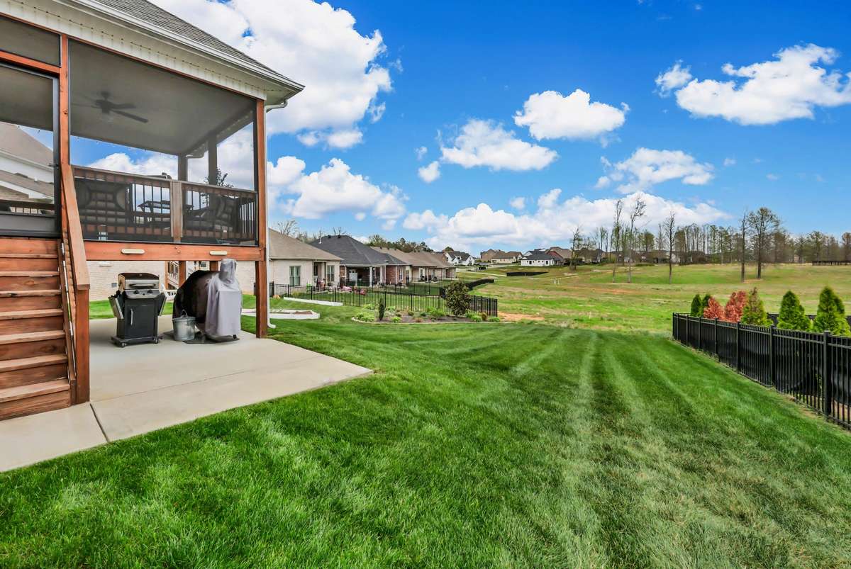 There is a patio for outdoor cooking below the covered screened deck.  The open green space beyond enhances the feeling of enjoyment!