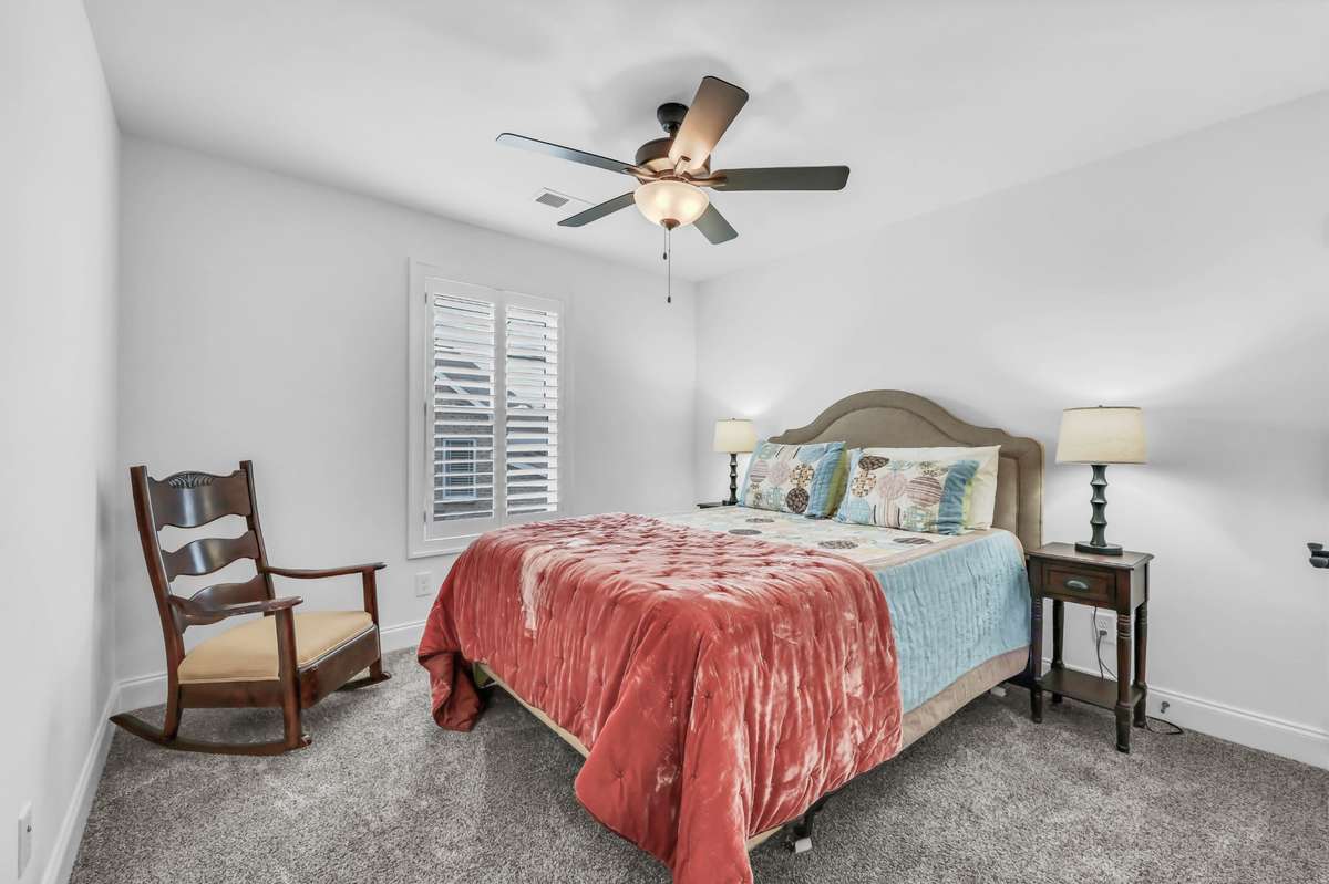 This is another bedroom upstairs to catch a good night's sleep.  It features carpet, ceiling fan,  and plantation shutters!