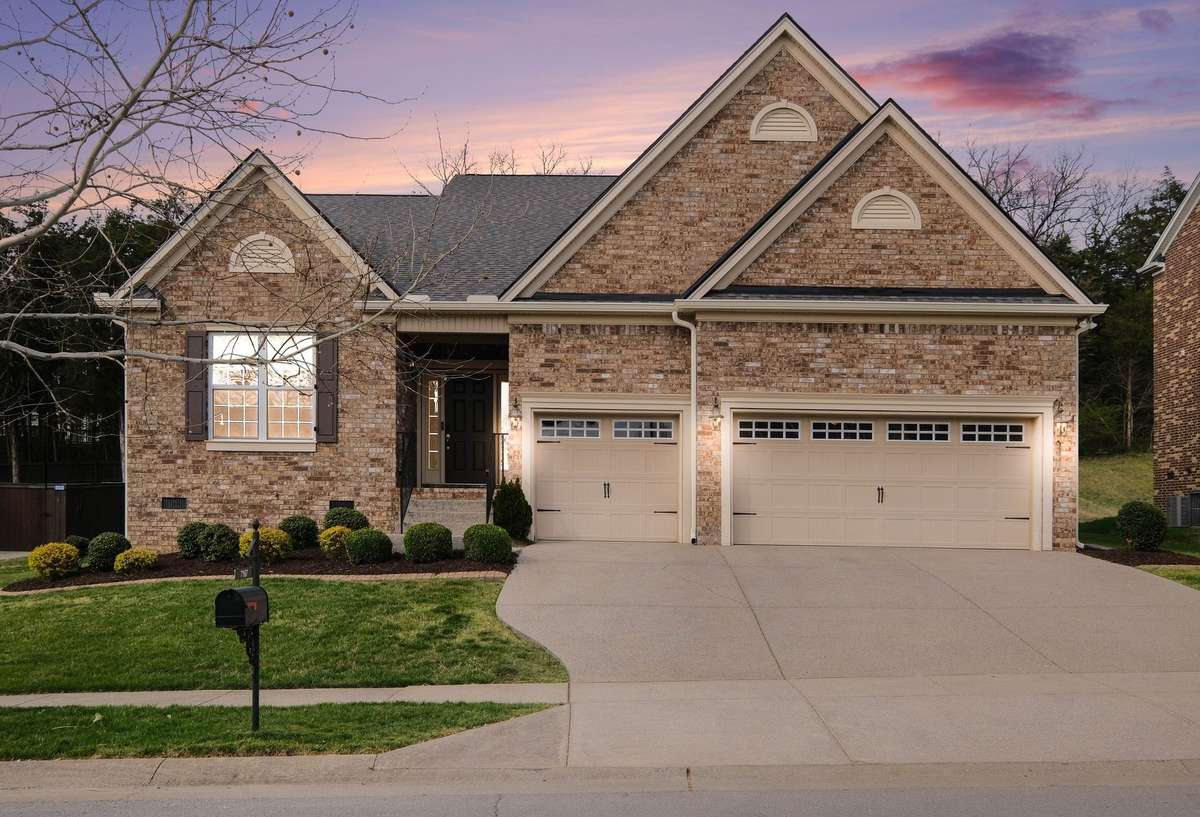 Beautifully maintained brick home with timeless curb appeal, featuring a spacious three-car garage, manicured landscaping, and a welcoming front entry.