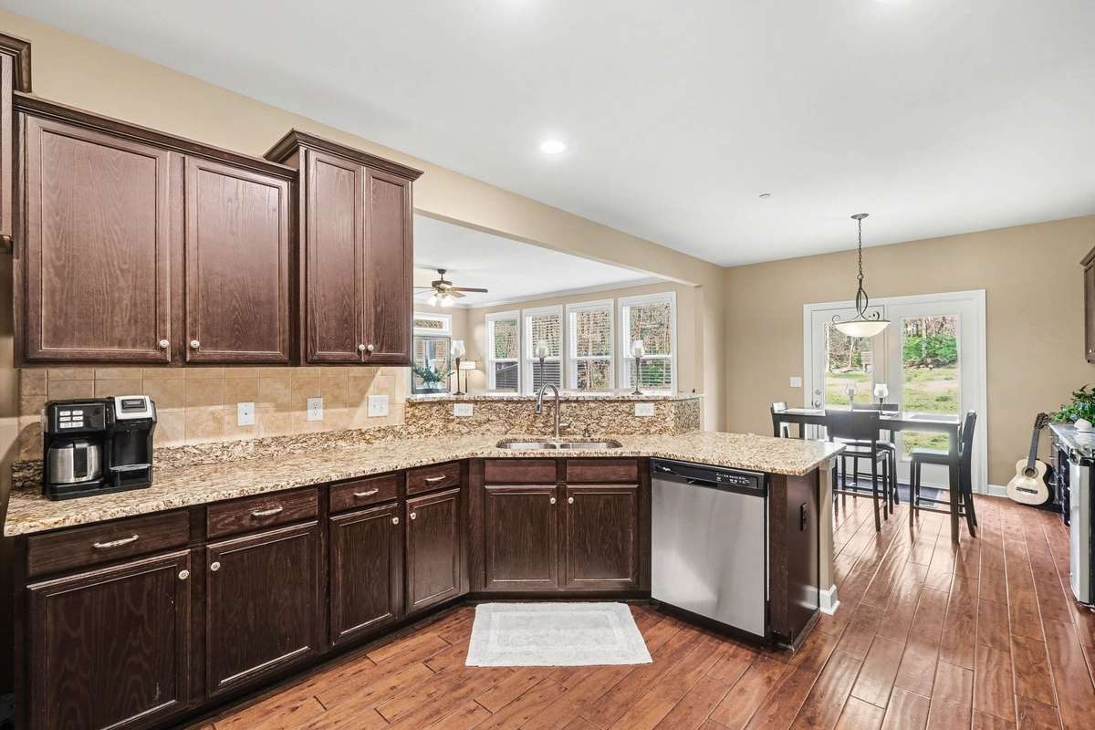 Well-appointed kitchen featuring granite countertops, ample cabinet space, and a functional layout overlooking the bright breakfast area—ideal for casual dining and entertaining.