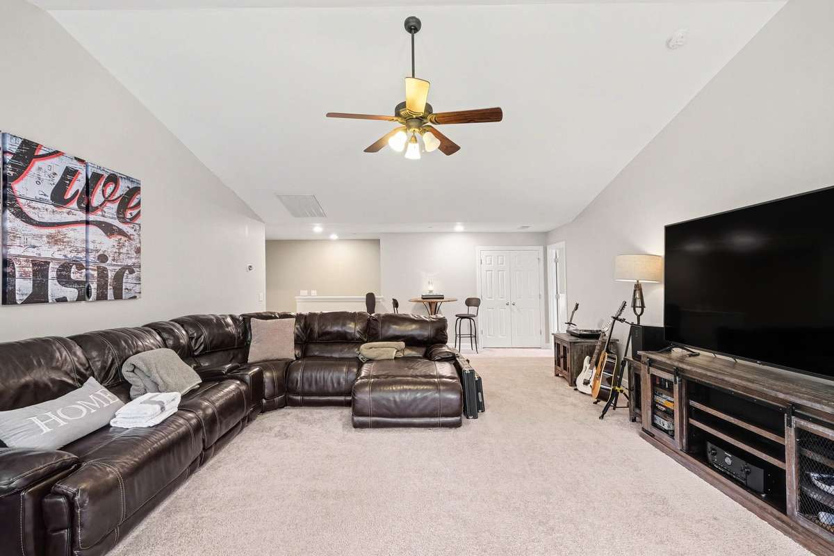 Expansive upstairs bonus room offering endless possibilities—perfect for a media room, game space, or secondary living area. Features plush carpeting, recessed lighting, and plenty of room to relax, entertain, or customize to fit your lifestyle.