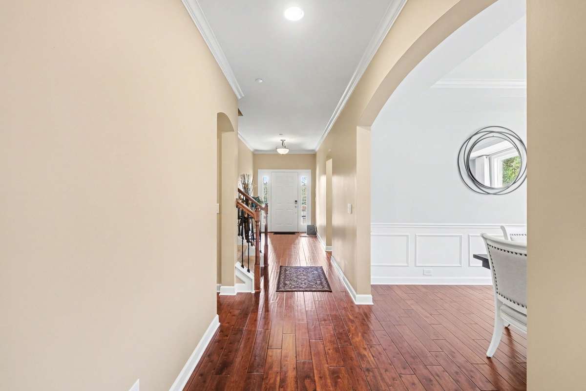 Inviting foyer with rich hardwood floors, elegant crown molding, and an open, light-filled layout.