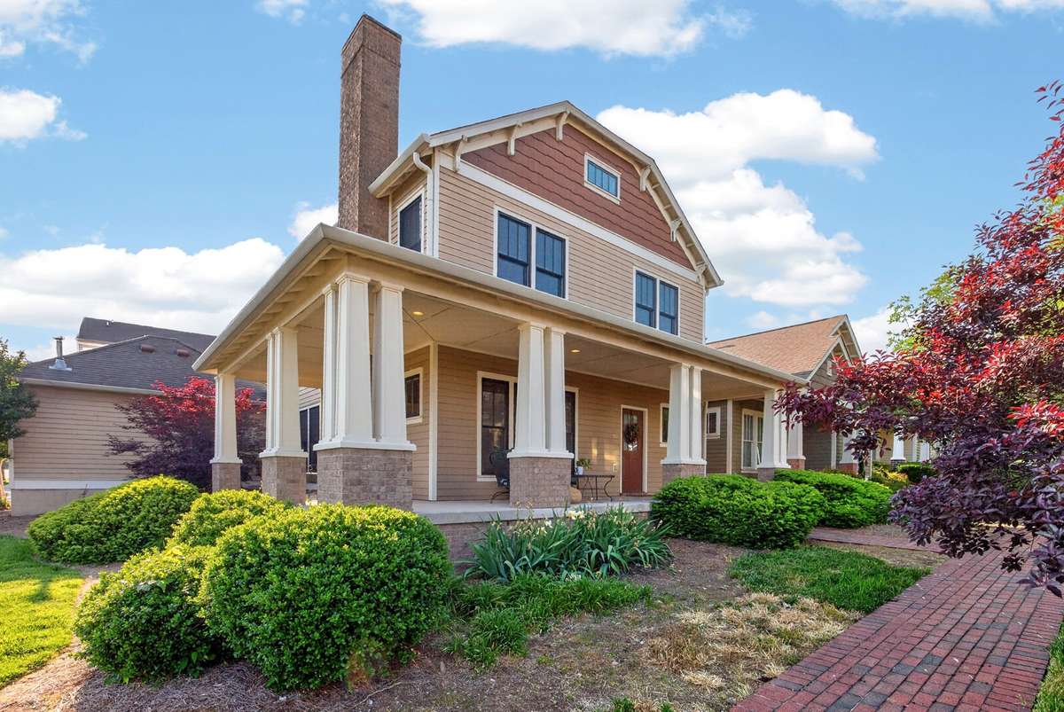 Exterior of the home on a corner lot with a wrap around porch.