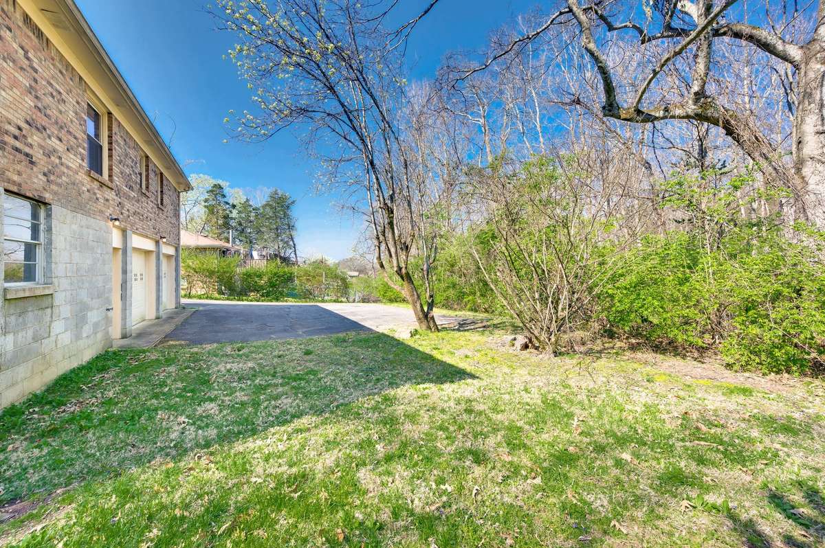 Plenty of parking in back and space to add a deck off the eat in kitchen. Privacy in the back with woods and a creek. Property line goes across the creek to the back left. Pink flags are from the back door neighbor and not this property.