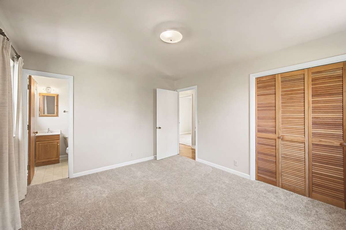 Primary bedroom with closet and half bath in view.