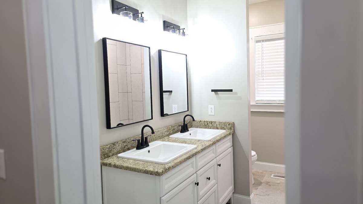 Hall bath with tiled floors and shower surround