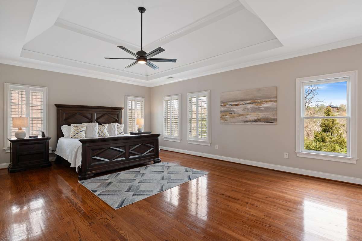 The primary suite is a large retreat with an abundance of windows, trey ceiling and hardwoods
