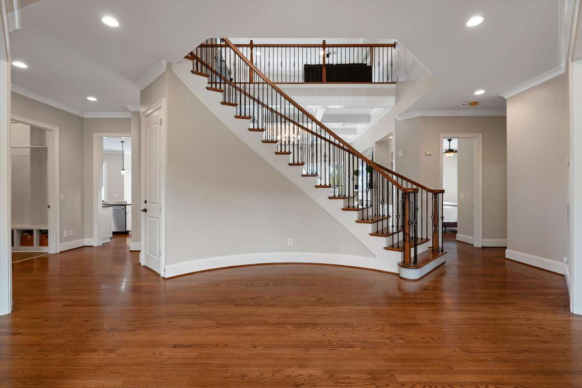 The entrance to the home is a showstopper. The elegant staircase has lovely iron railing and is surrounded by hardwoods.