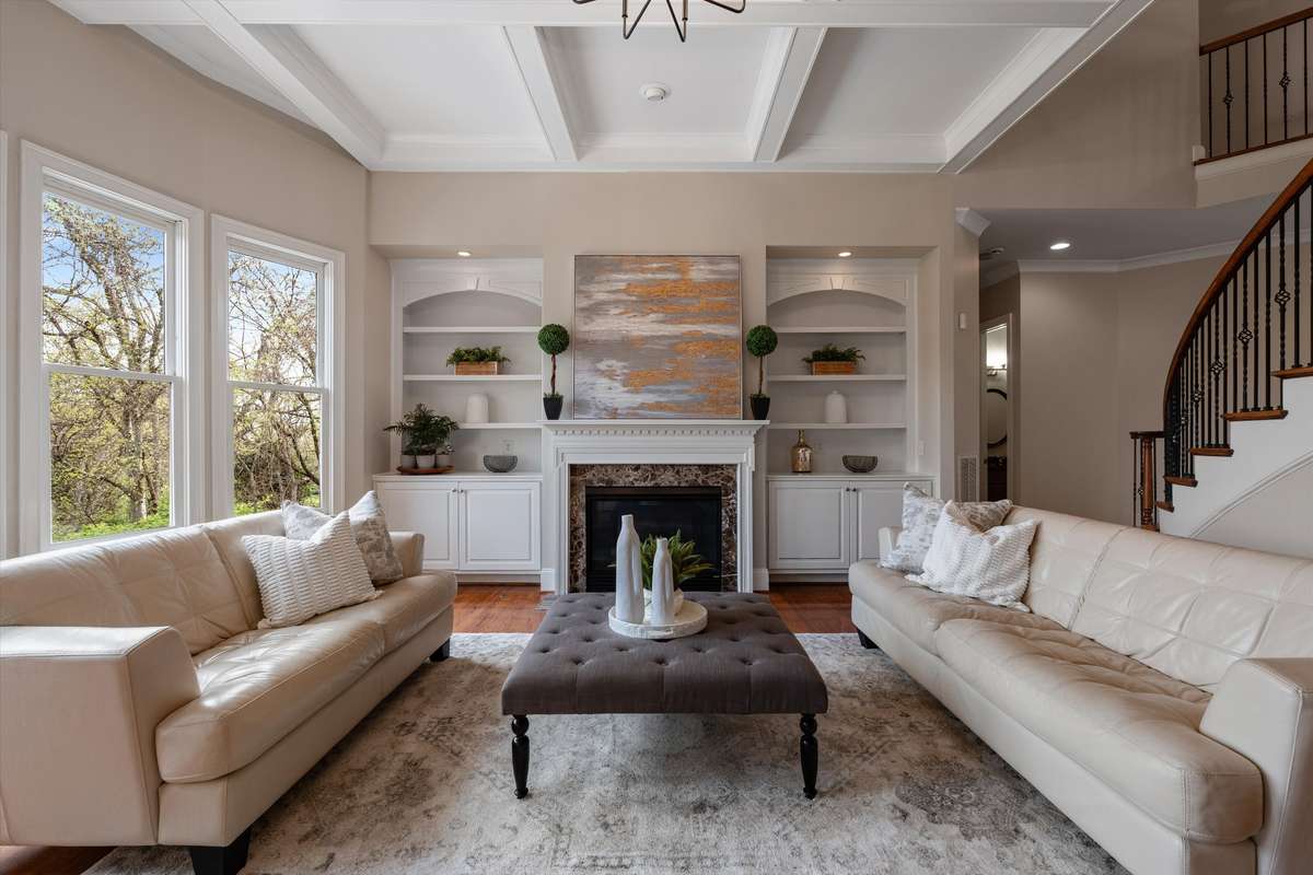 The formal living room is large enough for a variety of seating options around the gas log fireplace
