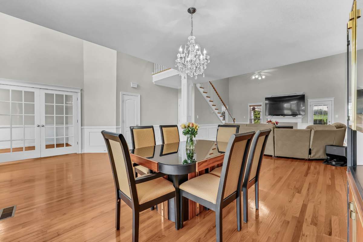 Formal Dining Room Features an Elegant Light Fixture, Crown Molding & Wainscoting!
