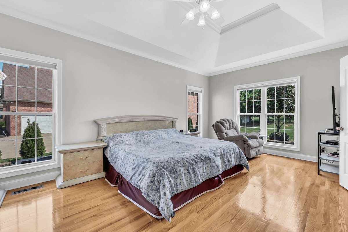 Large Primary Suite on the Main Level w/ Hardwood Flooring, Crown Molding & Vaulted Tray Ceiling!