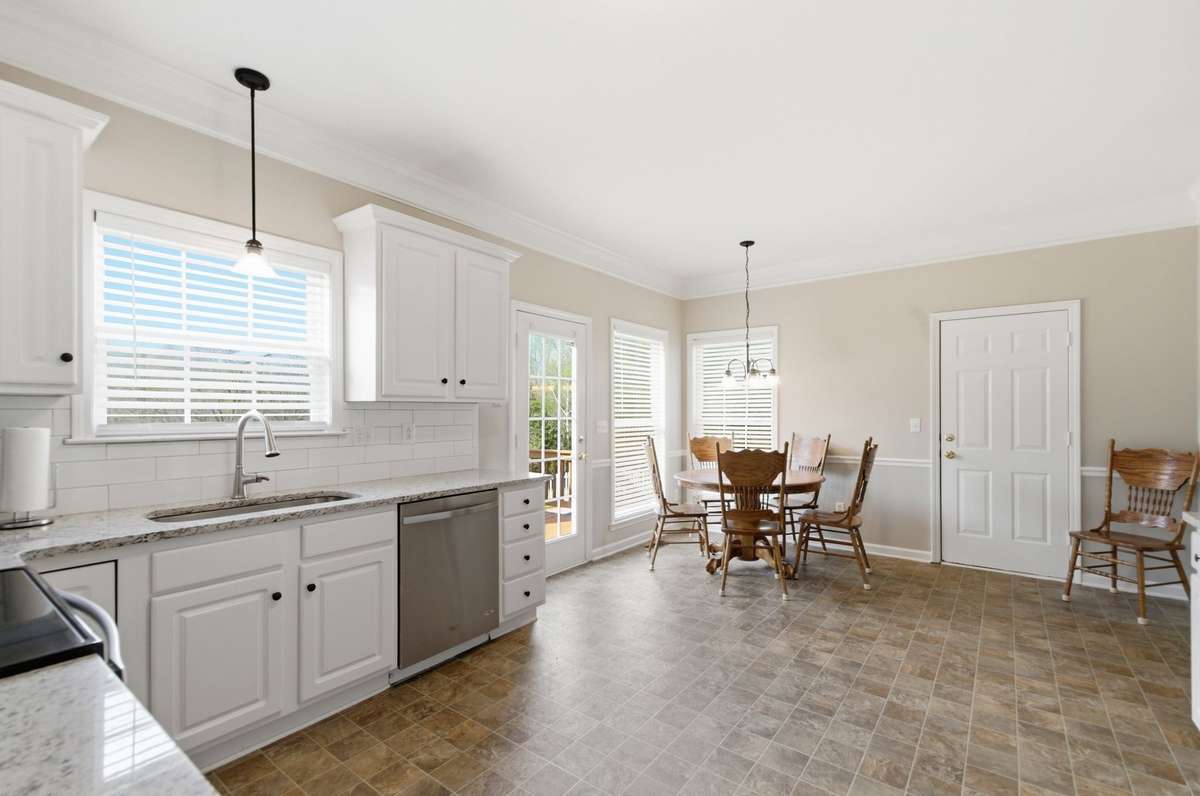 Sunlit breakfast nook surrounded by windows, creating a warm and inviting space for casual meals.