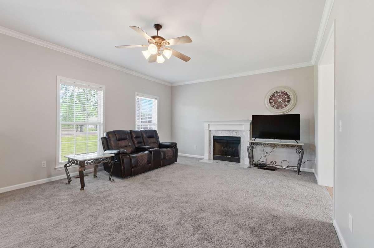 Comfortable layout with ceiling fan and large windows, creating a bright and welcoming atmosphere.