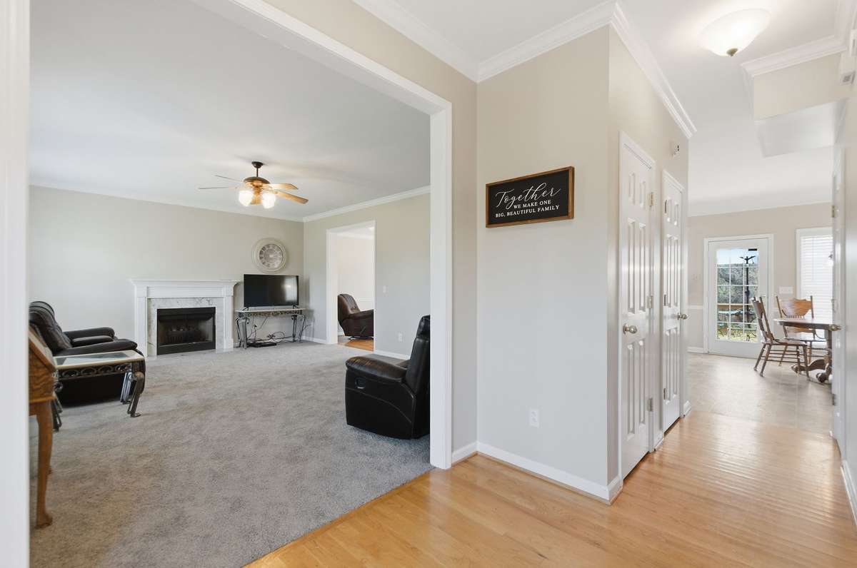 Open hallway connects living spaces seamlessly, offering a glimpse into both the main living area and dining space.