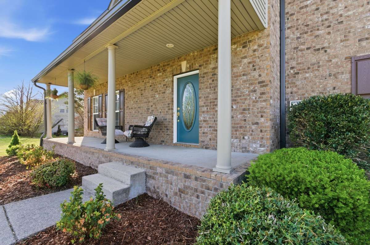 Inviting covered front porch with columns and seating area, perfect for relaxing and enjoying the outdoors.