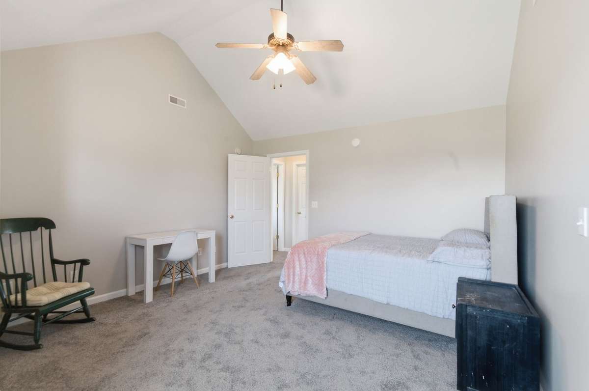 Generously sized bedroom with neutral tones and easy access to closet and hallway.