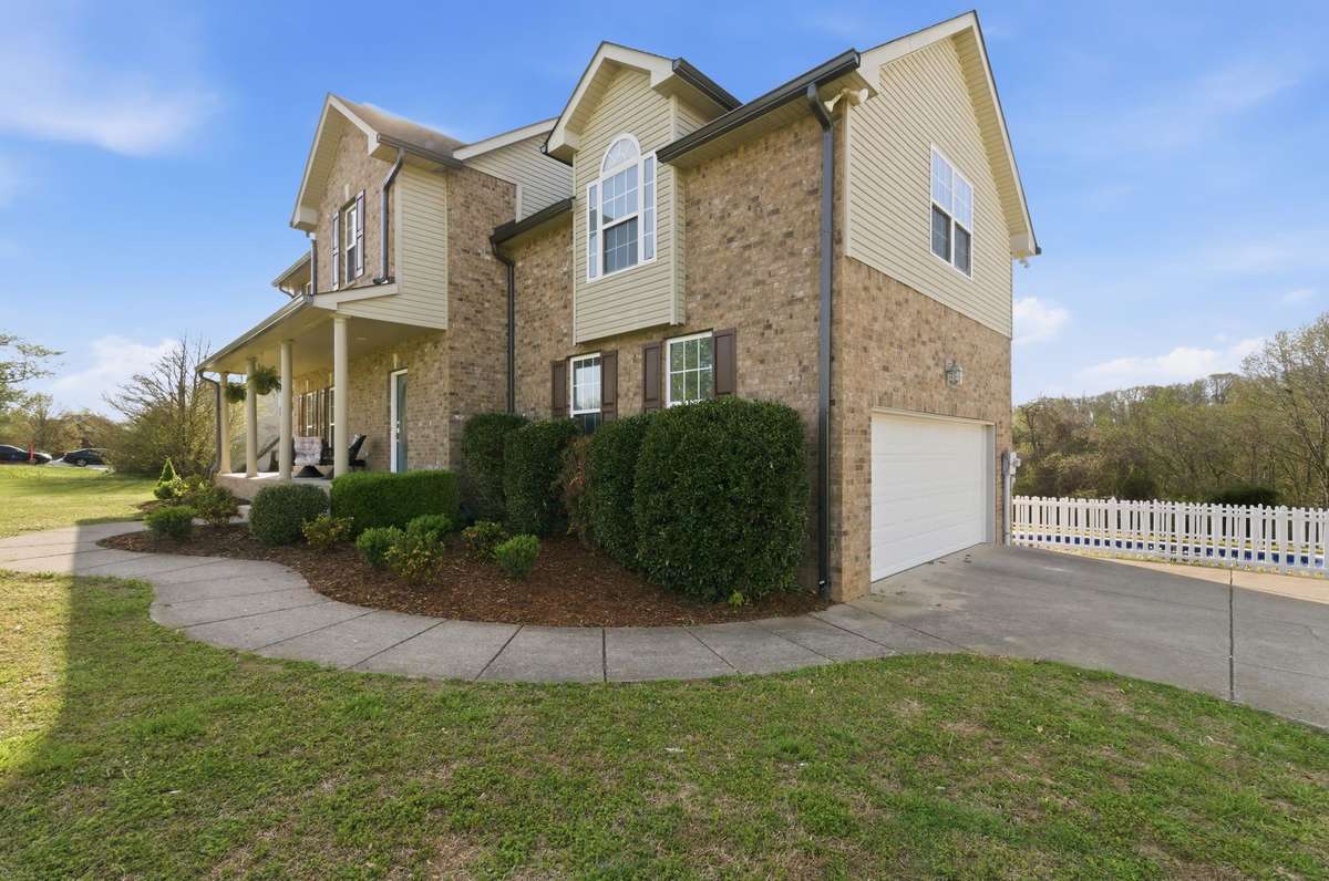 Combination of brick and siding adds visual interest, with neatly trimmed shrubs and a clean, well-kept exterior.