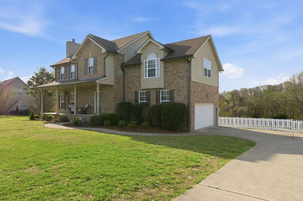 Side-entry garage with extended driveway provides ample parking space, complemented by a generous lawn.