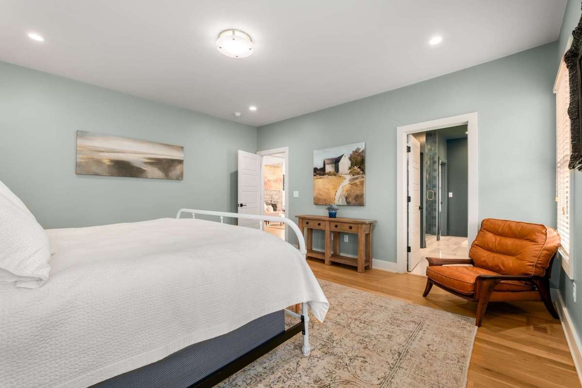 Alternate view of primary bedroom and bathroom.  Room is spacious enough to fit a king size bed set, and seating.