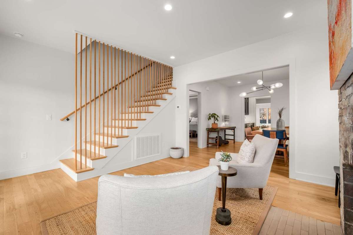 Alternate view of the front entry living area, staircase, and view into the dining room
