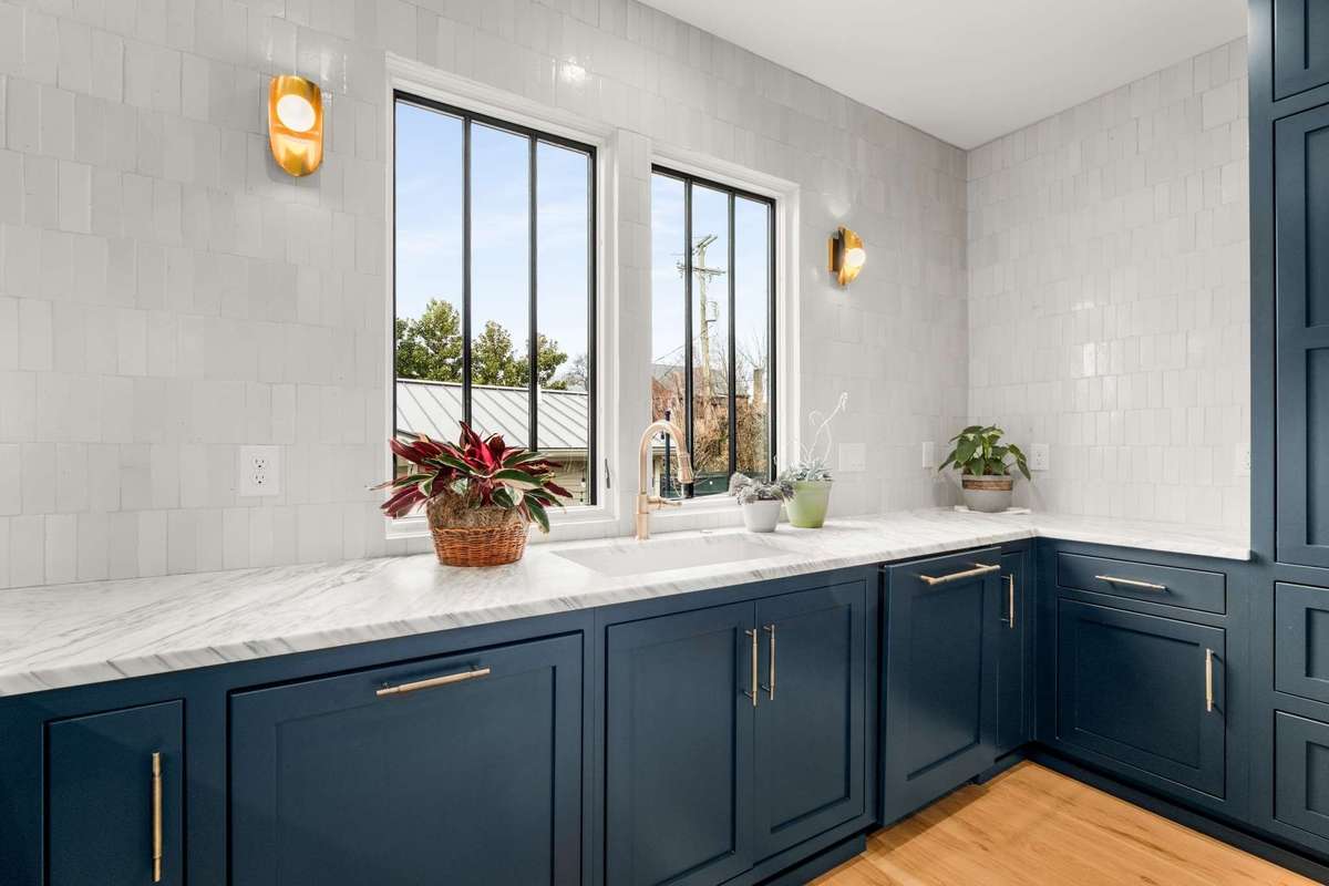 custom cabinets offer paneled appliances, pull out trash, and a custom color.  designer lighting also completes the kitchen experience nicely.
