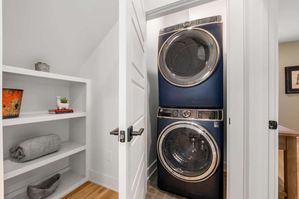 View of downstairs laundry area, just outside the primary bedroom.  There is a second side by side set in an upstairs laundry room as well.   Built in shelving for your decor or linens.