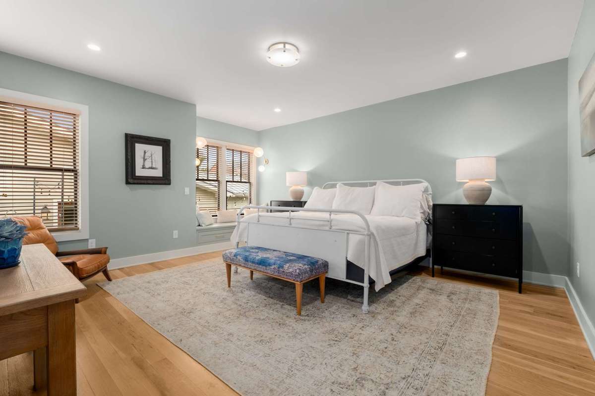 The primary suite is located on the main floor, and also features overhead lighting, large windows, a reading bench / seat with complimentary lighting, and ensuite access to the primary bath / closet.