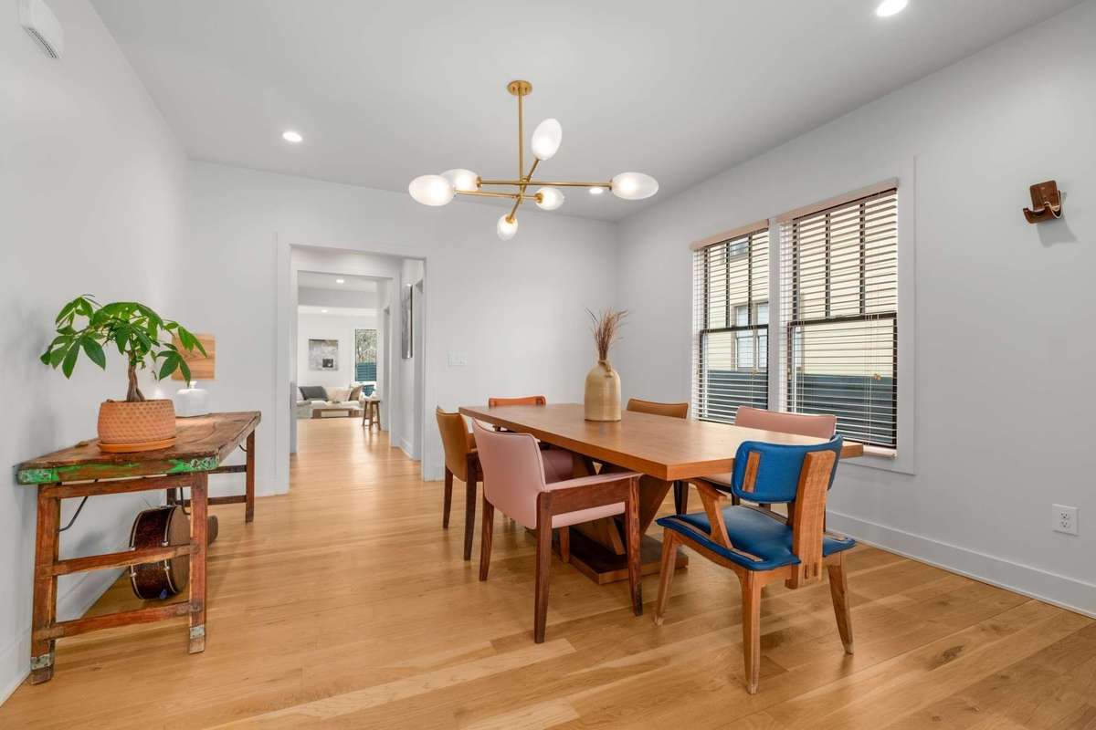The dining room provides enough seating for 6+, and the same concept of large windows / natural light, over-head lighting, designer fixture, and hardwood flooring.  Adjacent to this space is the wet bar / coffee area, and powder bath
