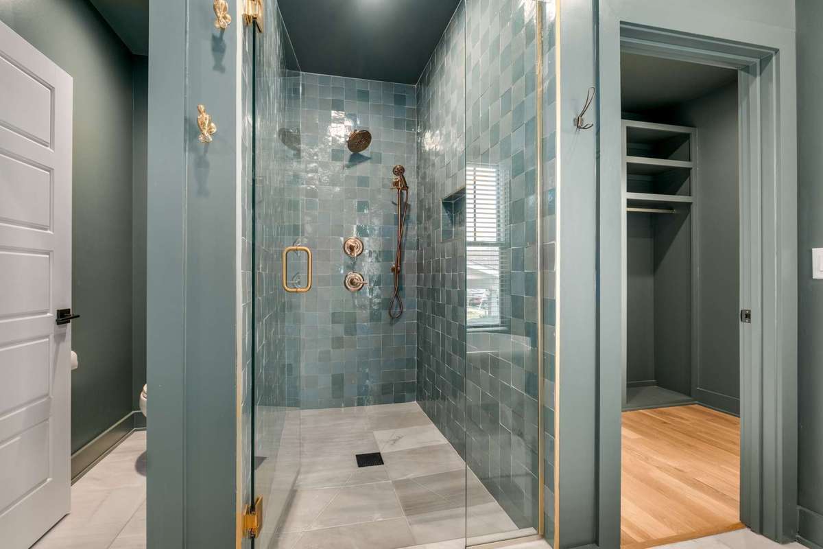 View of the primary bathroom shower, walk in closet access, and private door to WC area.
