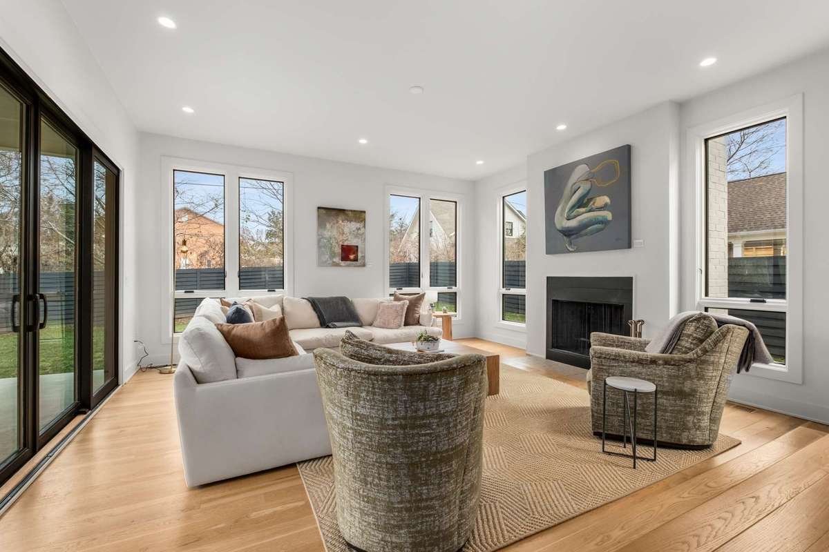 The oversized sunk living room brings in natural light from three sides, has access to one side of the home via friends and family entry, and a large glass sliding door on the other to covered outdoor entertaining area.  New wood burning fireplace