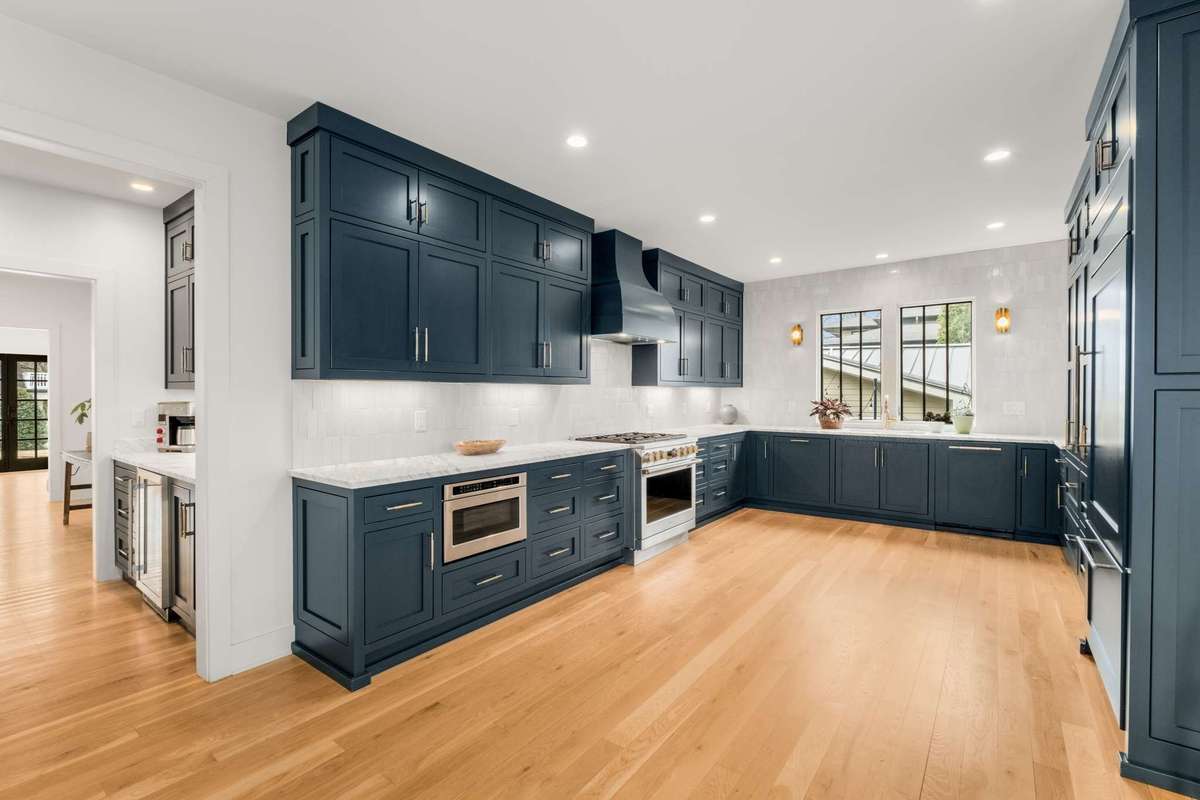 The kitchen is setup nicely, appointed with upgraded paneled appliances, oversized gas cooking, picture window at the sink, tile backsplash, & beautiful designer cabinet. There is a large pantry & coat closet (not pictured) also accessed from here