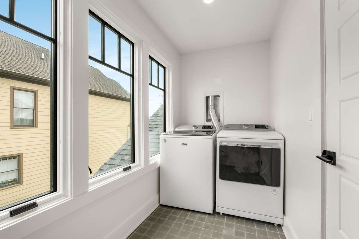 Upstairs full laundry room.  Both washers and dryers convey with the property