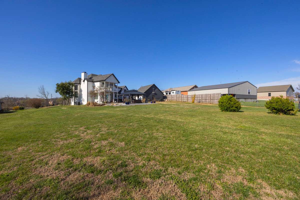 Rear of Home. Double Covered Porches. Extensive Driveway. Detached Garage with Additional Living Area Above.
