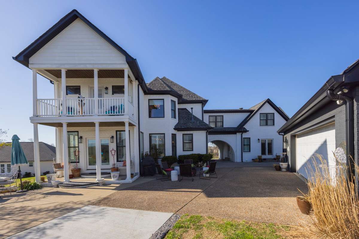Rear of Home. Double Covered Porches. Extensive Driveway. Detached Garage with Additional Living Area Above.
