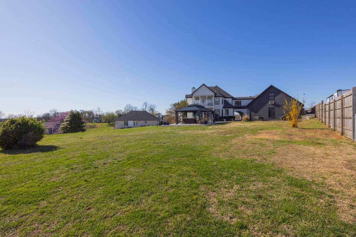 Rear of Home. Double Covered Porches. Extensive Driveway. Detached Garage with Additional Living Area Above.