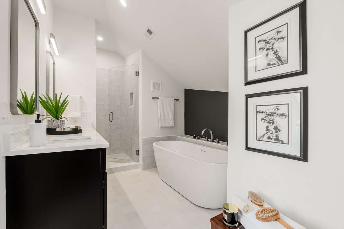 The ensuite primary bathroom is complete with dual vanities, a soaking tub, and a separate, tiled shower.