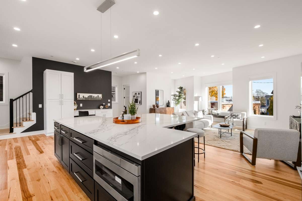 Note the large pantry adjacent to the kitchen and the seamless flow from the kitchen island to the dining table and the living room.