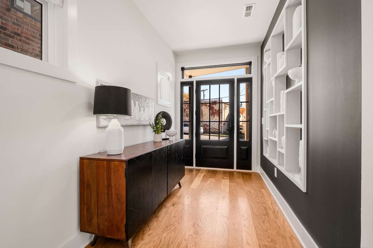 Notice the warm, hickory floors throughout the home, seen here drenched in sunlight from the sleek, window-paned door.