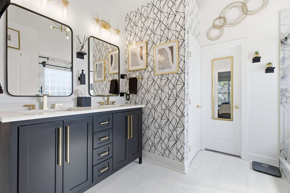 En Suite Bath has beautiful updated vanity, mirrors, lighting, wallpaper, walk in shower.