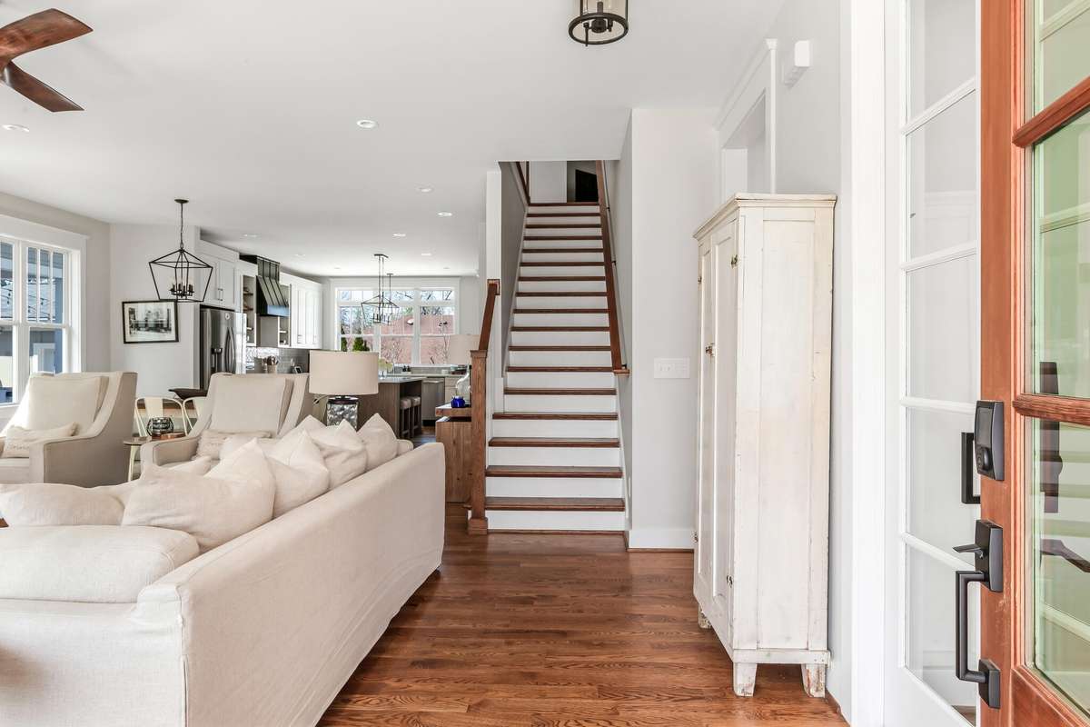 Inviting entry opens to a dedicated office on the right and a spacious open-concept living area with hardwoods.
