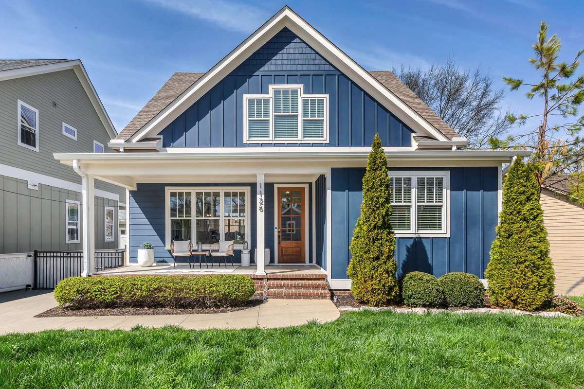 Charming exterior with covered front porch, manicured landscaping, and inviting entry.