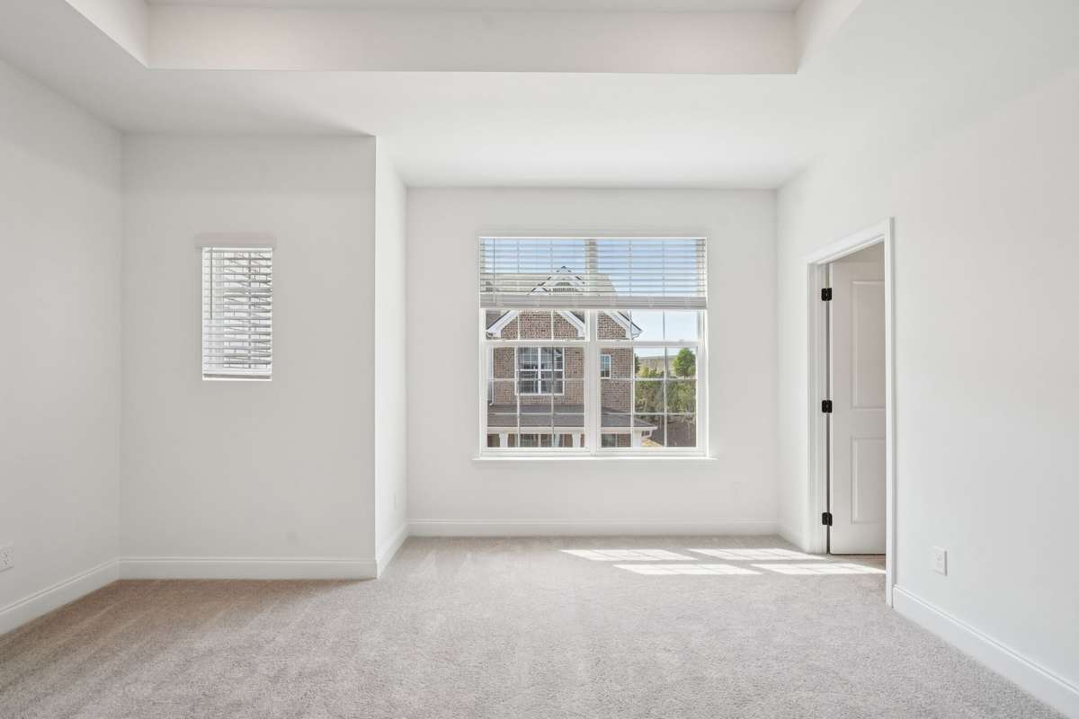 Another view of the spacious primary bedroom, showcasing its airy layout, abundant natural light, and serene, comfortable atmosphere.