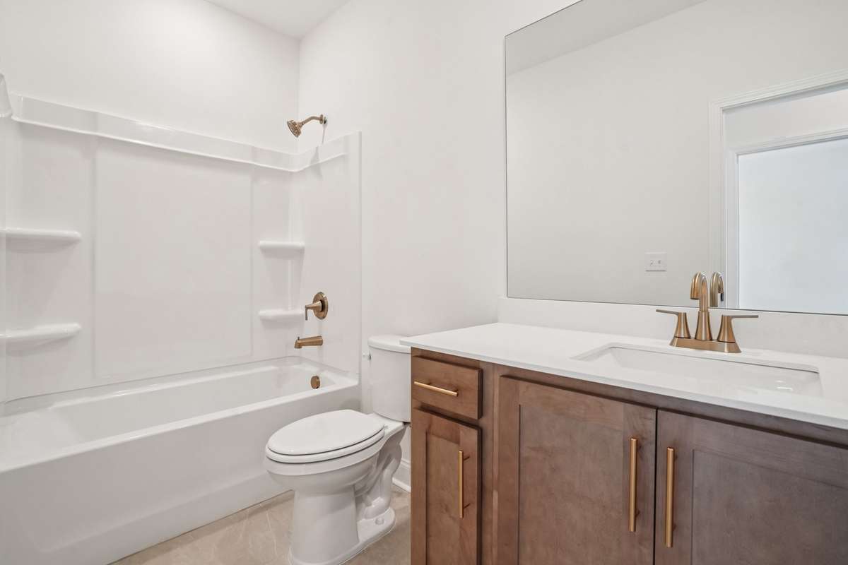 Bath 2 features tile flooring and quartz countertops, combining durability with a modern. clean look.